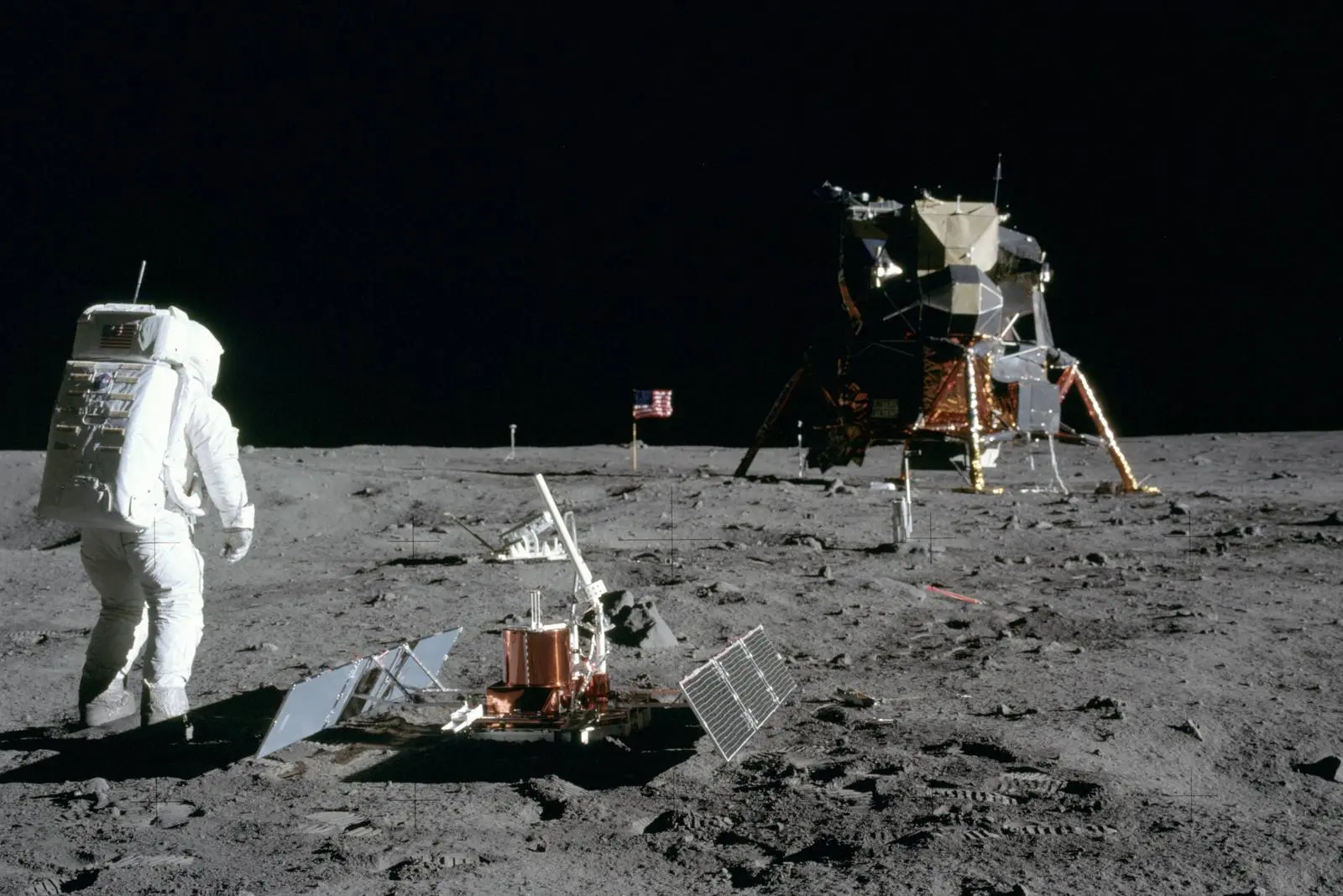 Buzz Aldrin beside the seismometer he has just deployed, with the flag and Eagle beyond, photographed by Armstrong, 20 July 1969