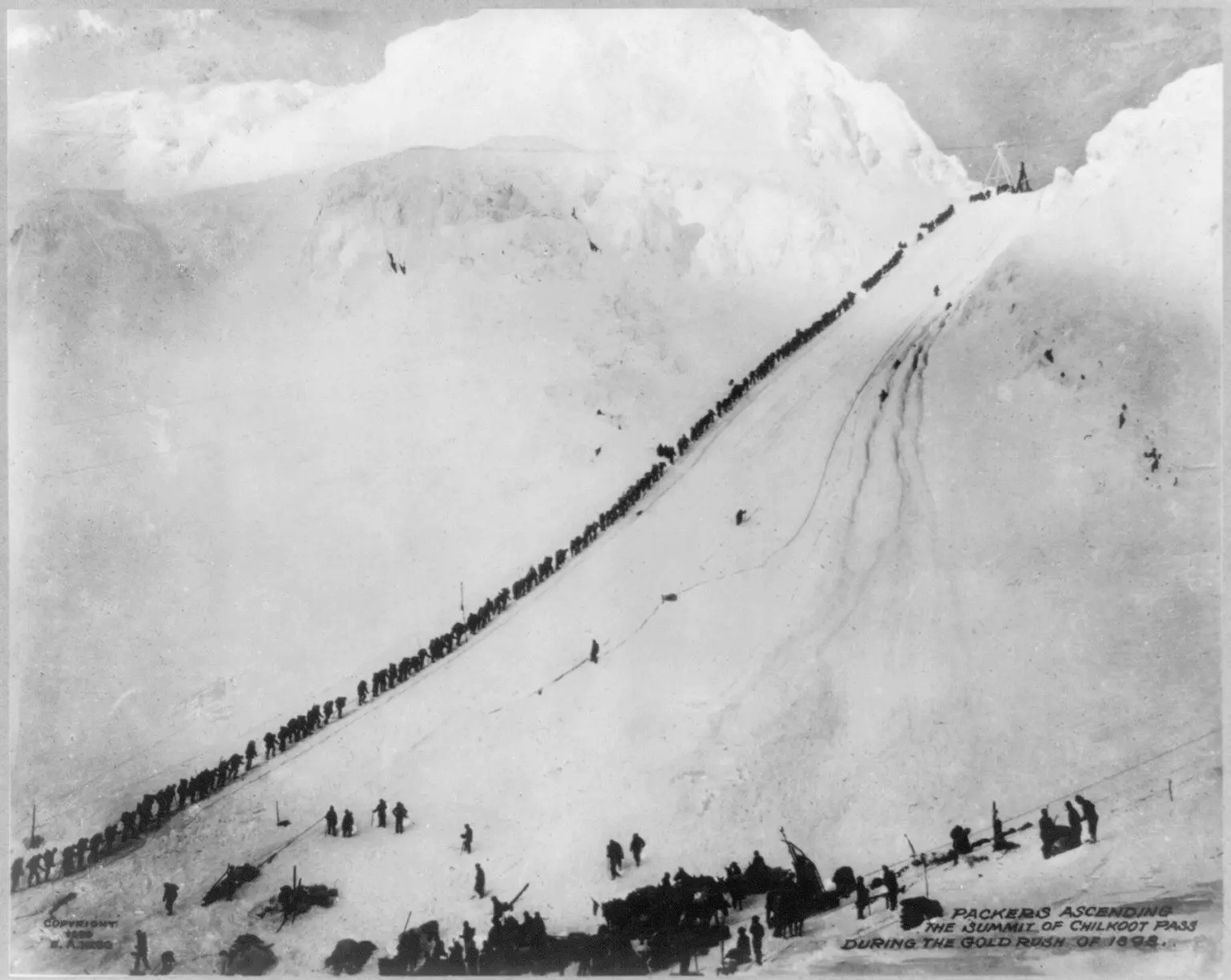 Packers climb to the summit of Chilkoot Pass on the trail from Dyea, Alaska, to the Klondike goldfields, 1898.
