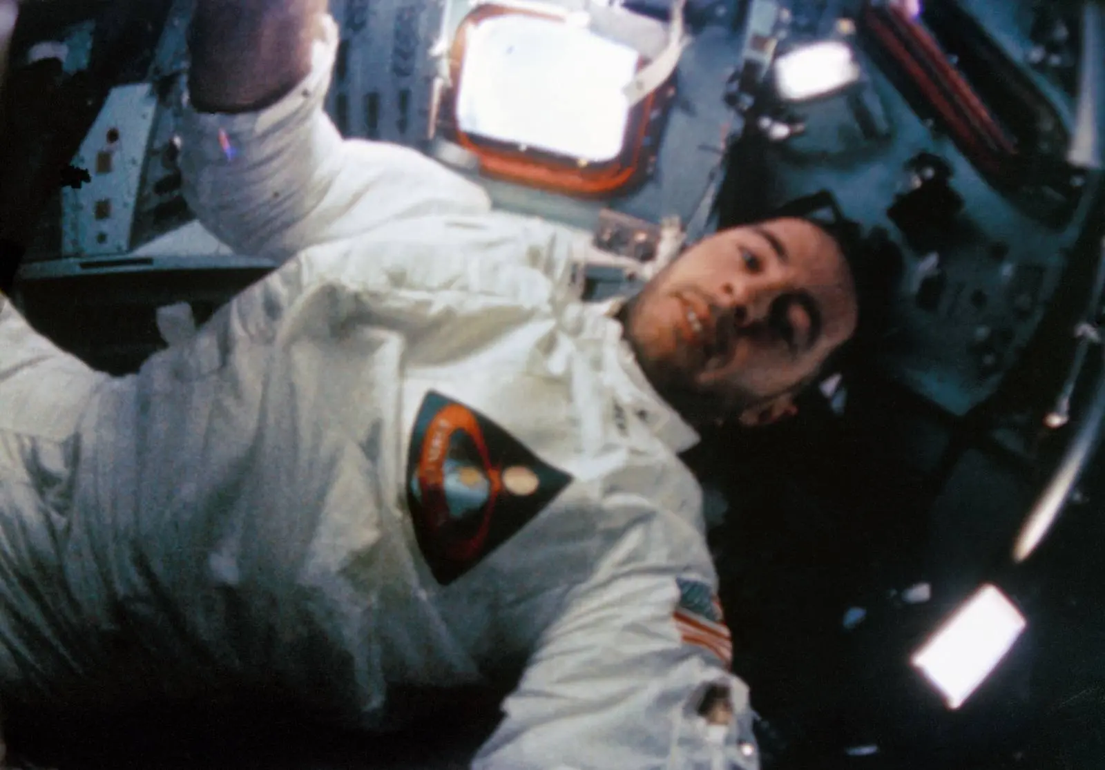 Bill Anders at work inside the command module, from the onboard 16mm movie camera (S68-56532)