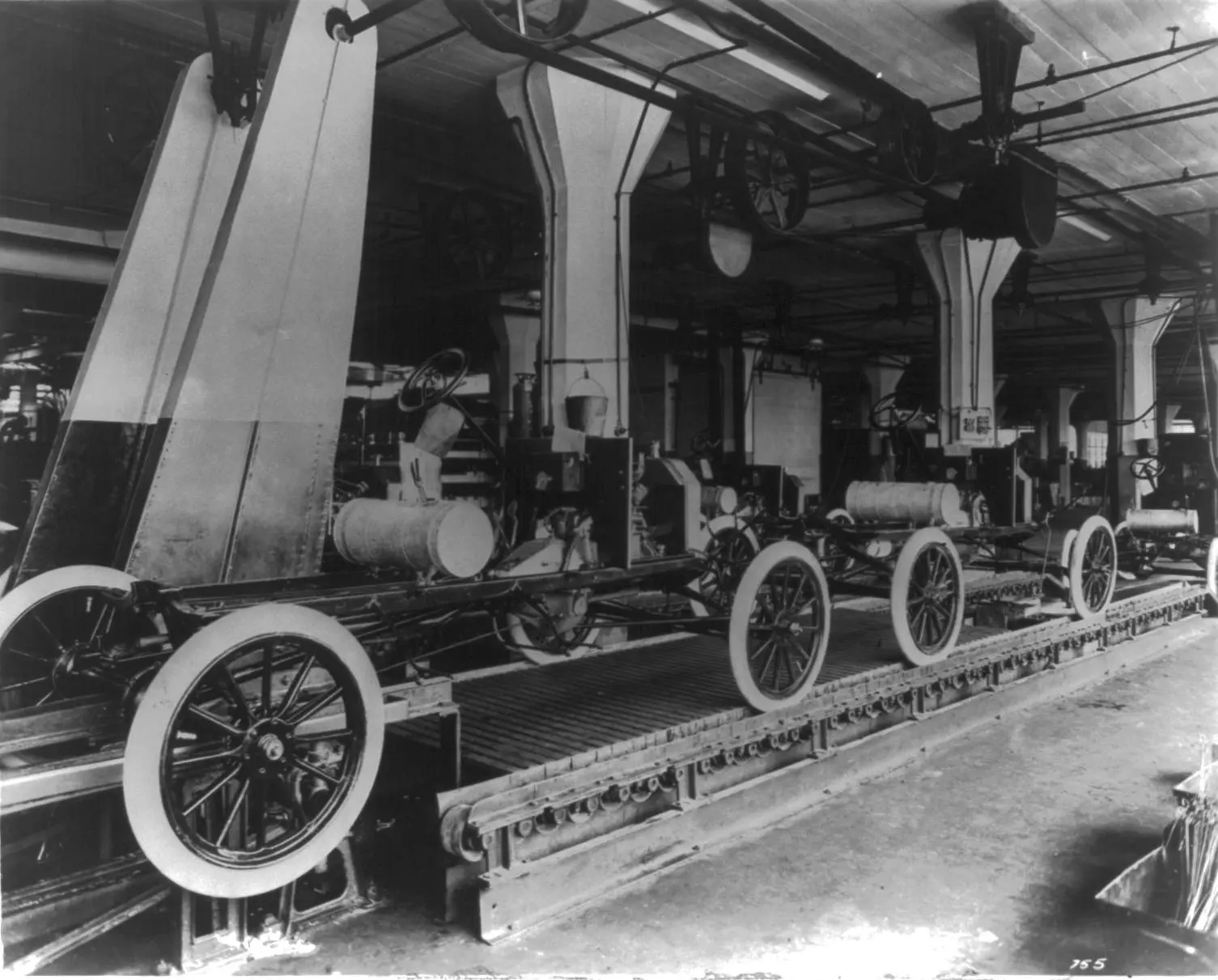 Model T chassis ride the moving assembly line at Highland Park.