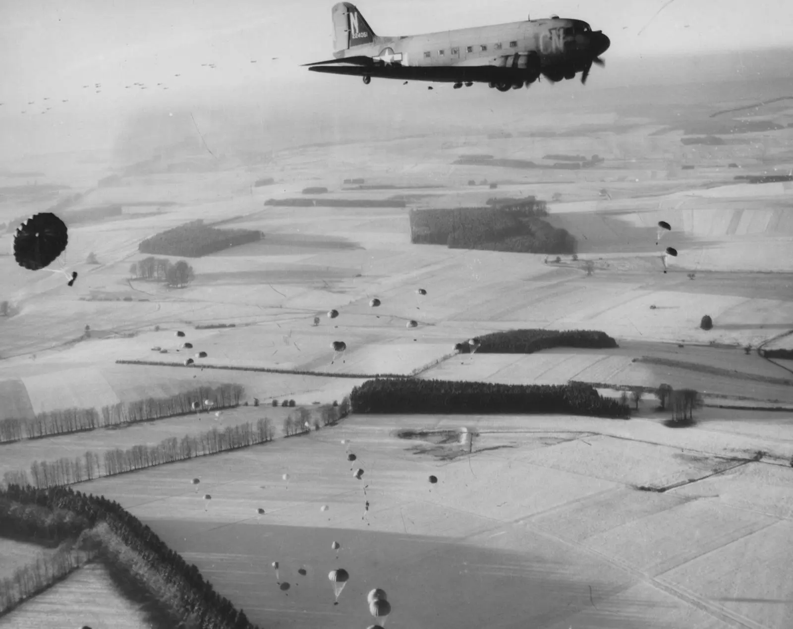 A C-47 of the IX Troop Carrier Command drops parachute bundles over the snowfields around Bastogne, 23 December 1944