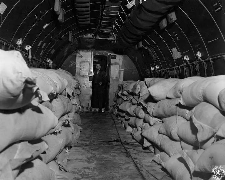 Flour sacks fill a C-54 at Rhein-Main before the flight to Tempelhof, 14 July 1948. This airplane had come from Alaska to join Operation Vittles.