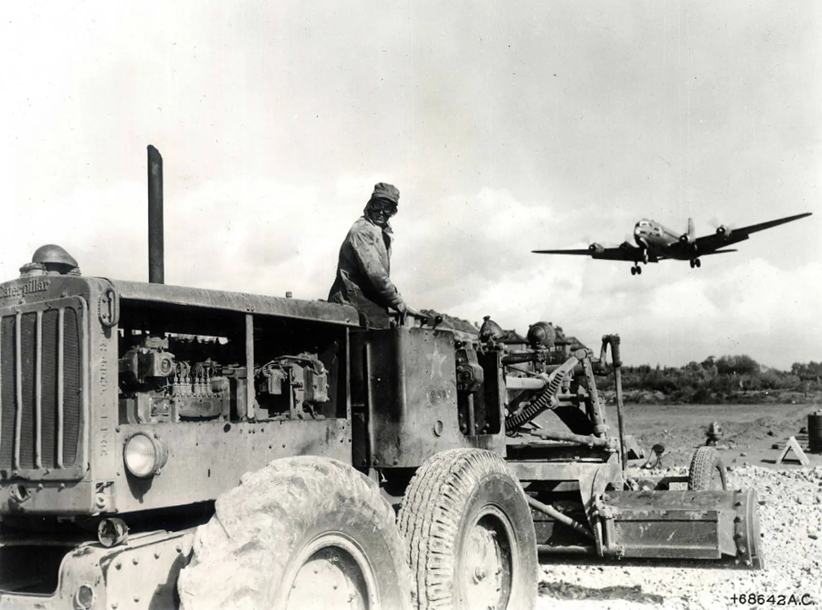 Pvt. William Moore of the 759th Engineers grades a new 5,500-foot runway at Tempelhof as a C-54 comes in to land.
