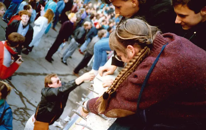 Berliners pull each other up onto the Wall, 10 November 1989, the day after it opened