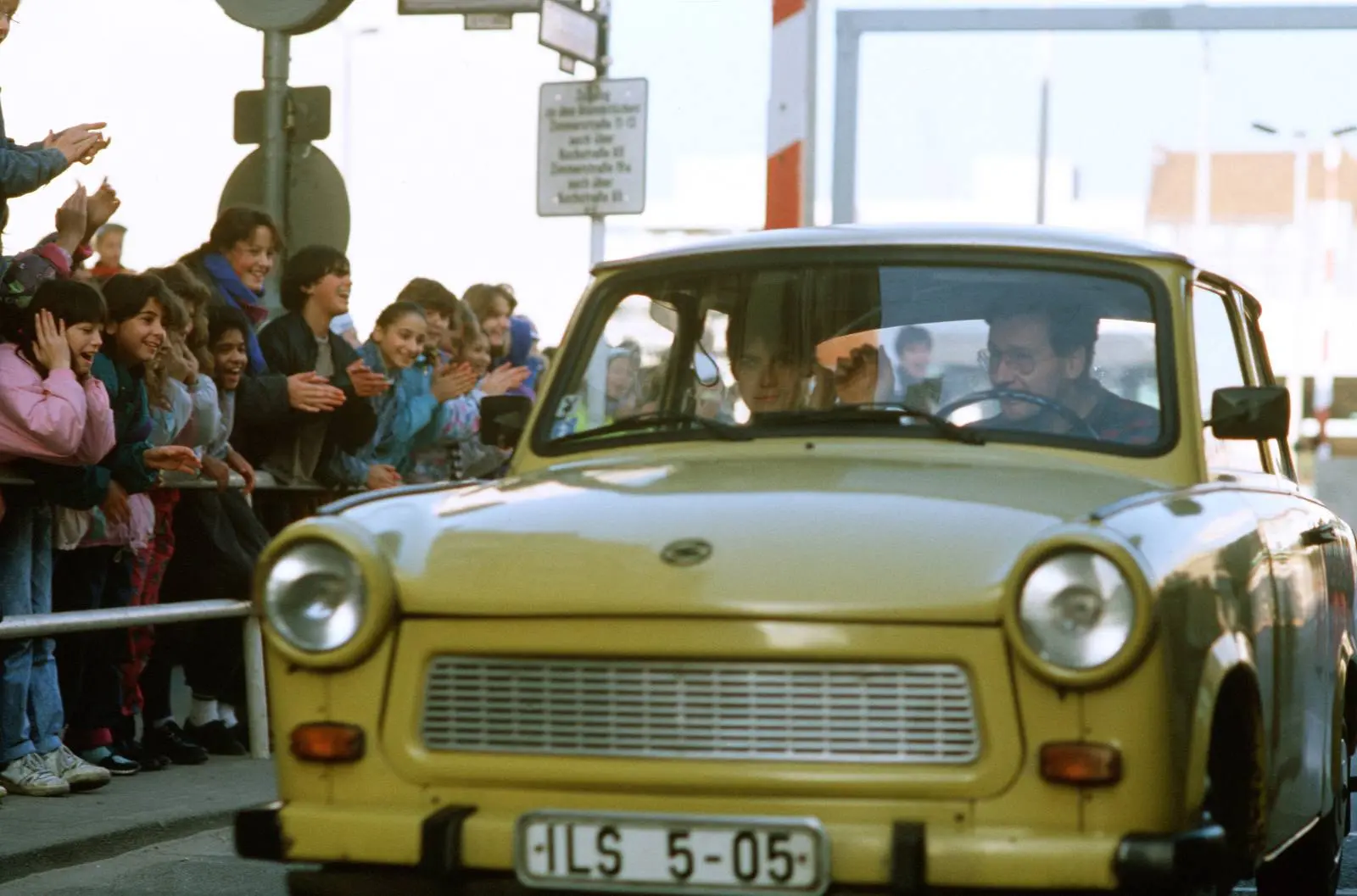 West Berliners cheer as East Germans drive through Checkpoint Charlie without border controls, November 1989