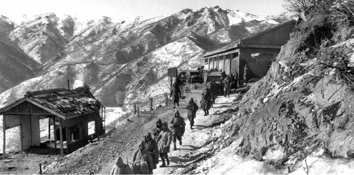 Marines march down Funchilin Pass past the gatehouse after the airdropped Treadway bridge went in, 9 December 1950 (A5408)