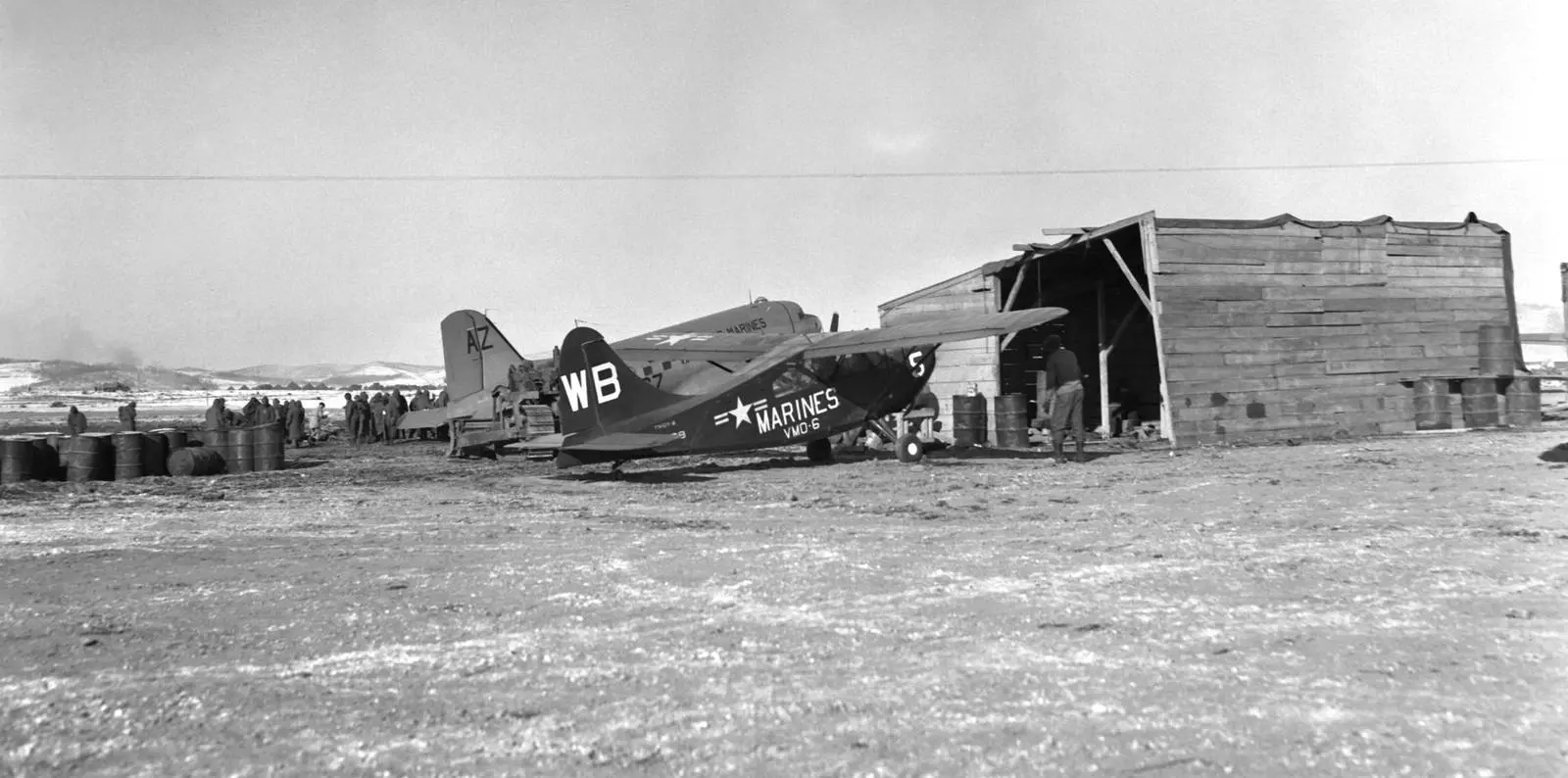 A VMO-6 light plane and a Marine R4D transport on the Hagaru-ri airstrip the engineers cut from frozen ground, December 1950