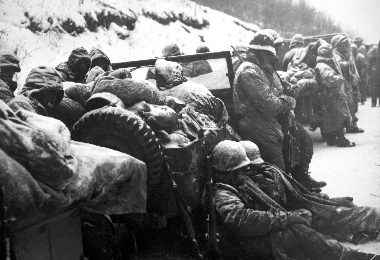 Frost-covered Marines of the 5th and 7th Regiments, who threw back three Chinese divisions at Yudam-ni, get the word to move out, December 1950 (127-N-A4852)