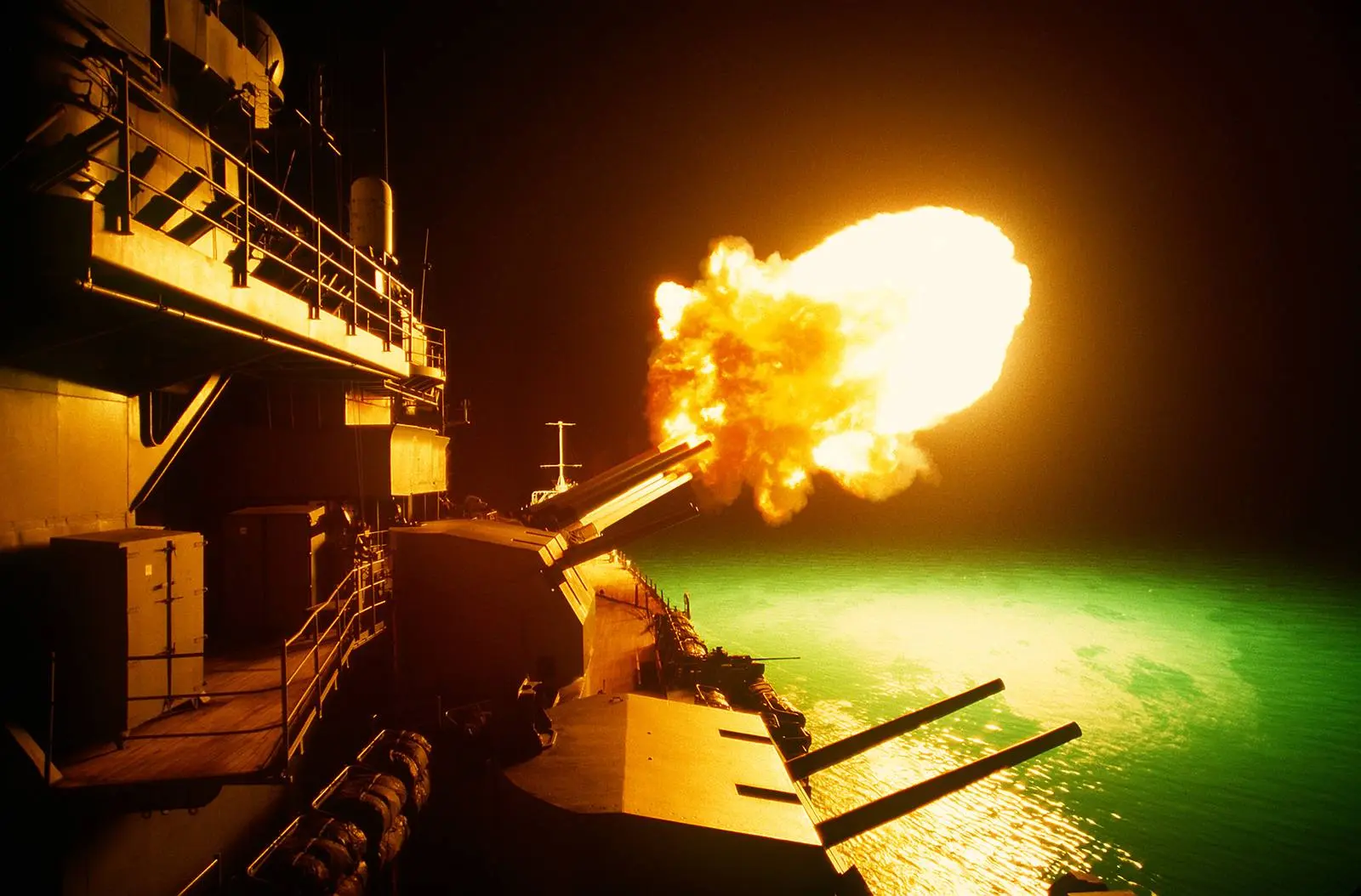 The 16-inch guns of the battleship USS Missouri fire on Iraqi positions along the northern Kuwaiti coast at night, 6 February 1991.