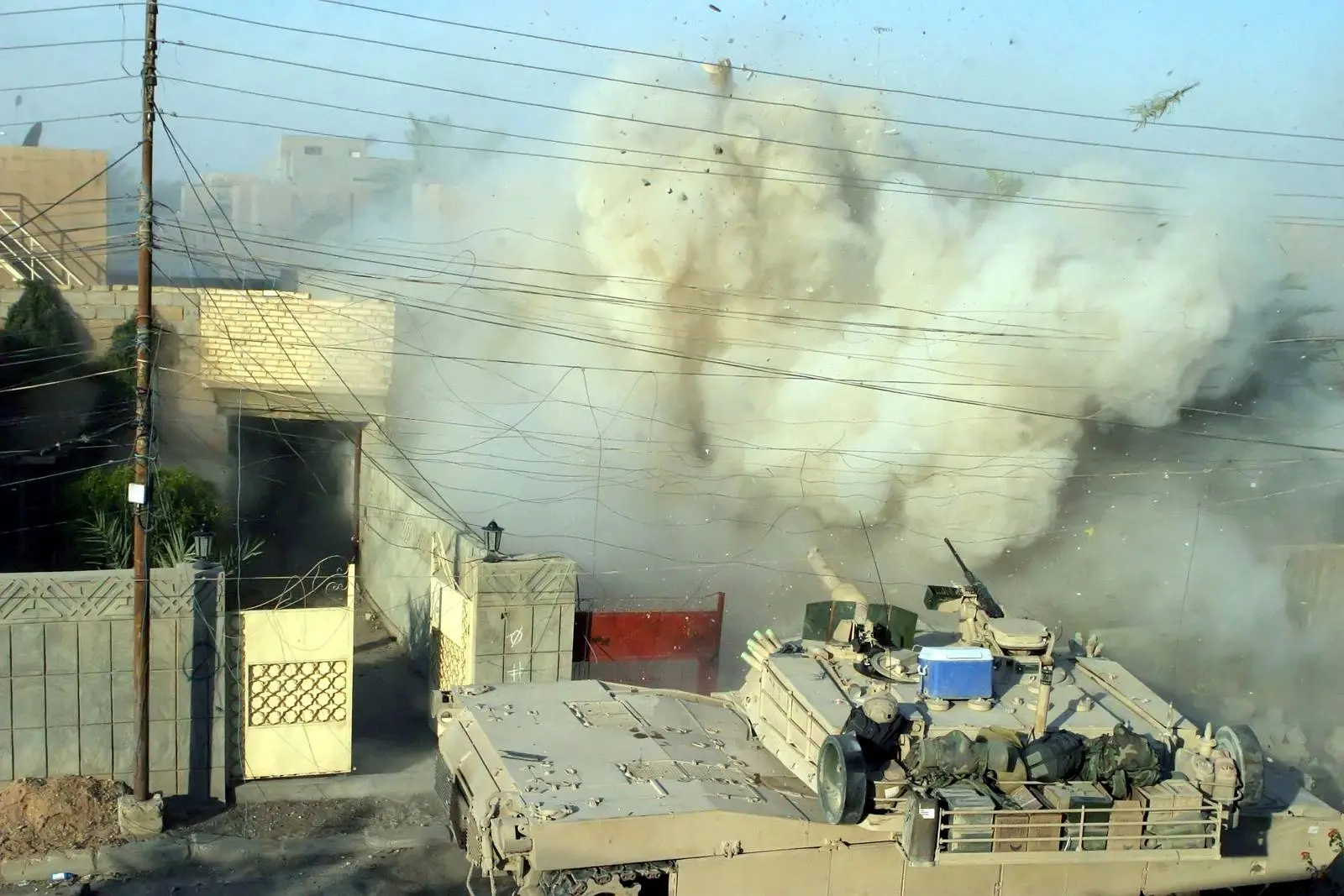 A Marine M1A1 Abrams of 2nd Tank Battalion fires its main gun into a building where insurgents had opened fire on Marines, Fallujah, 10 December 2004.