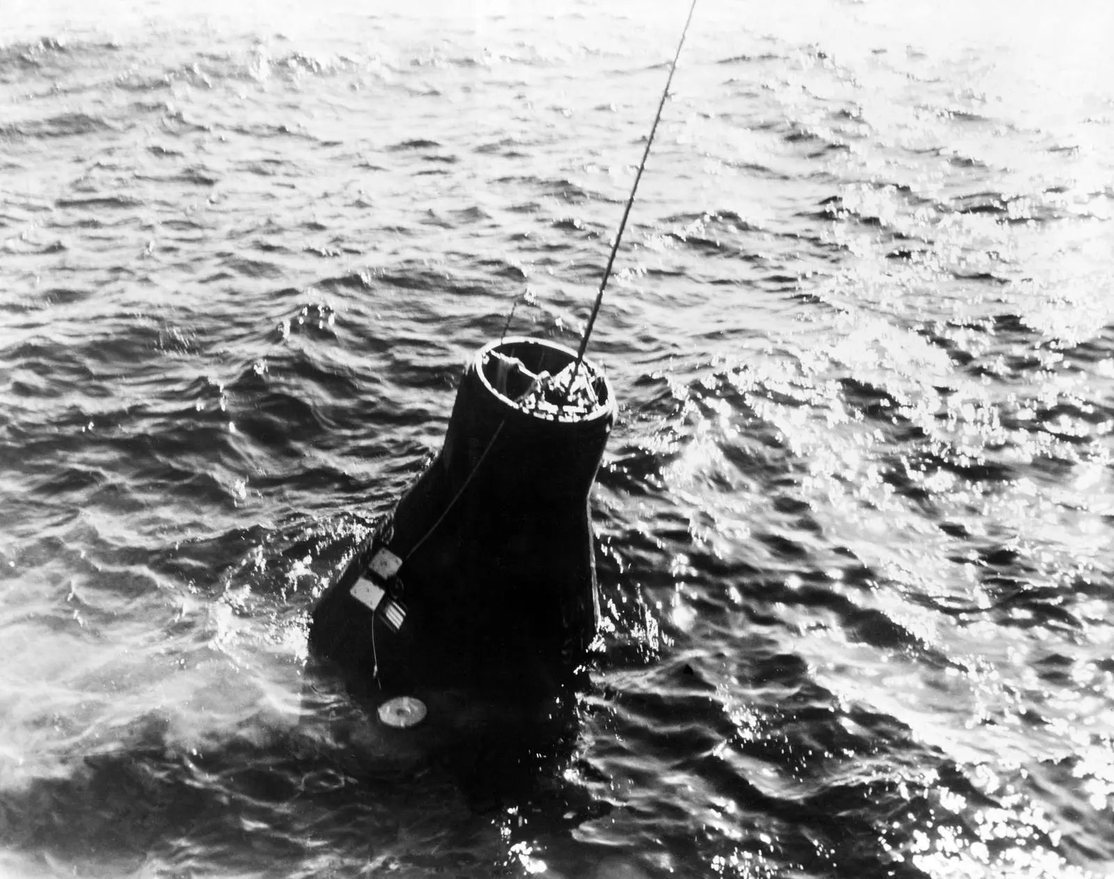 Friendship 7 in the Atlantic, cable attached, as the destroyer USS Noa hoists it aboard, 20 February 1962 (S62-00941)