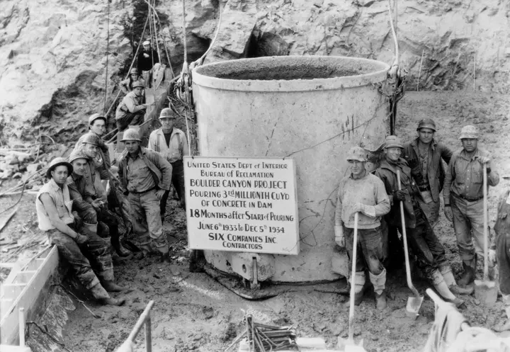 Workers pose with the bucket that placed the three-millionth cubic yard of concrete in Boulder Dam, December 5, 1934