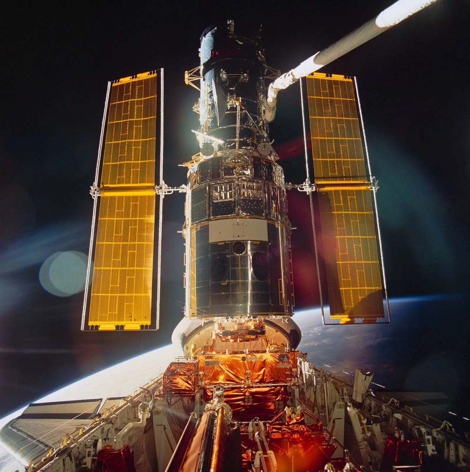 Hubble, its new solar arrays unfurled, gleams in Endeavour’s payload bay just before its release back into orbit, December 1993 (STS061-99-009).