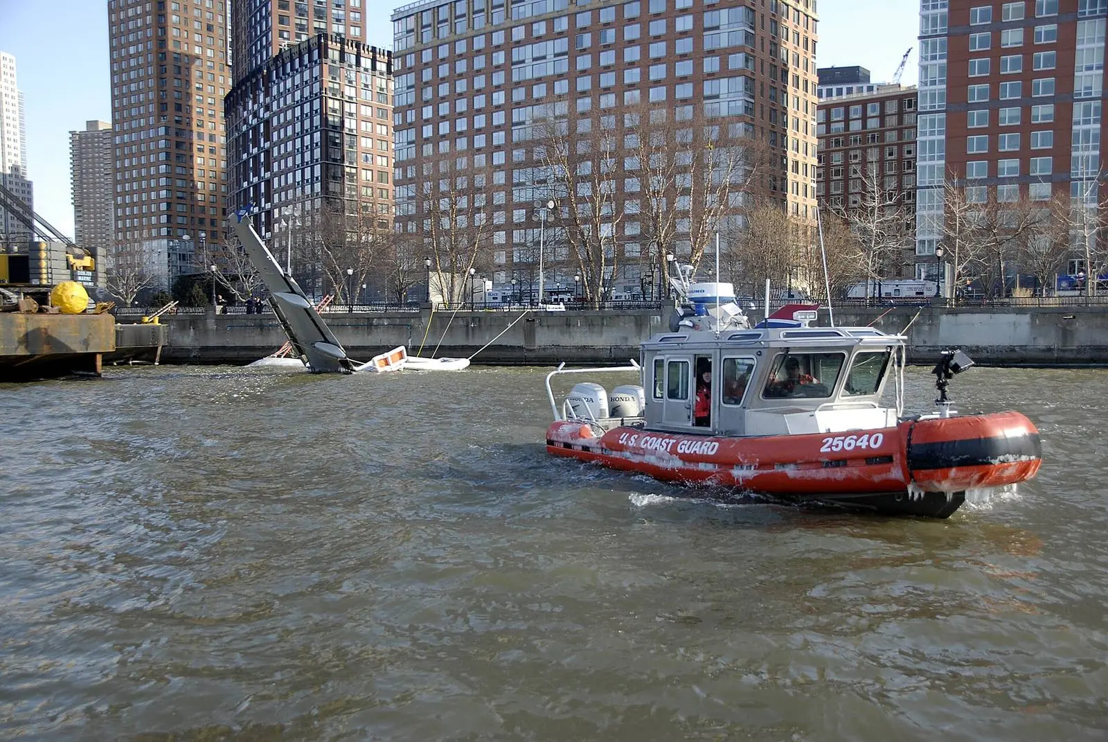 Coast Guard boat 25640, one of the boats that answered the ditching, guards the moored airliner at Battery Park City the next day