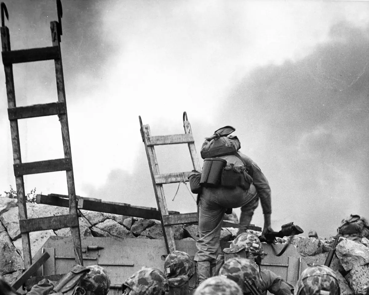 1st Lt. Baldomero Lopez leads the 3d Platoon, Company A, 1st Battalion, 5th Marines over the Red Beach seawall, 15 September 1950. He was killed minutes later (NH 96876).