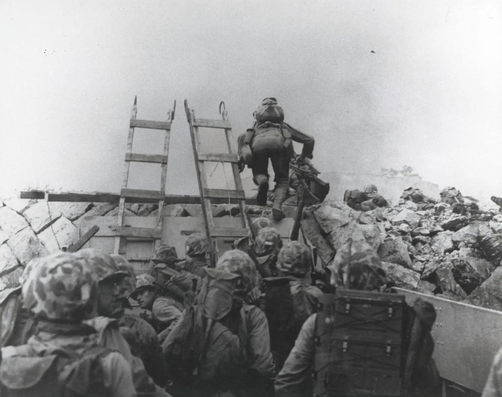 Marines climb wooden scaling ladders over the seawall from their landing craft at Inchon, 15 September 1950.