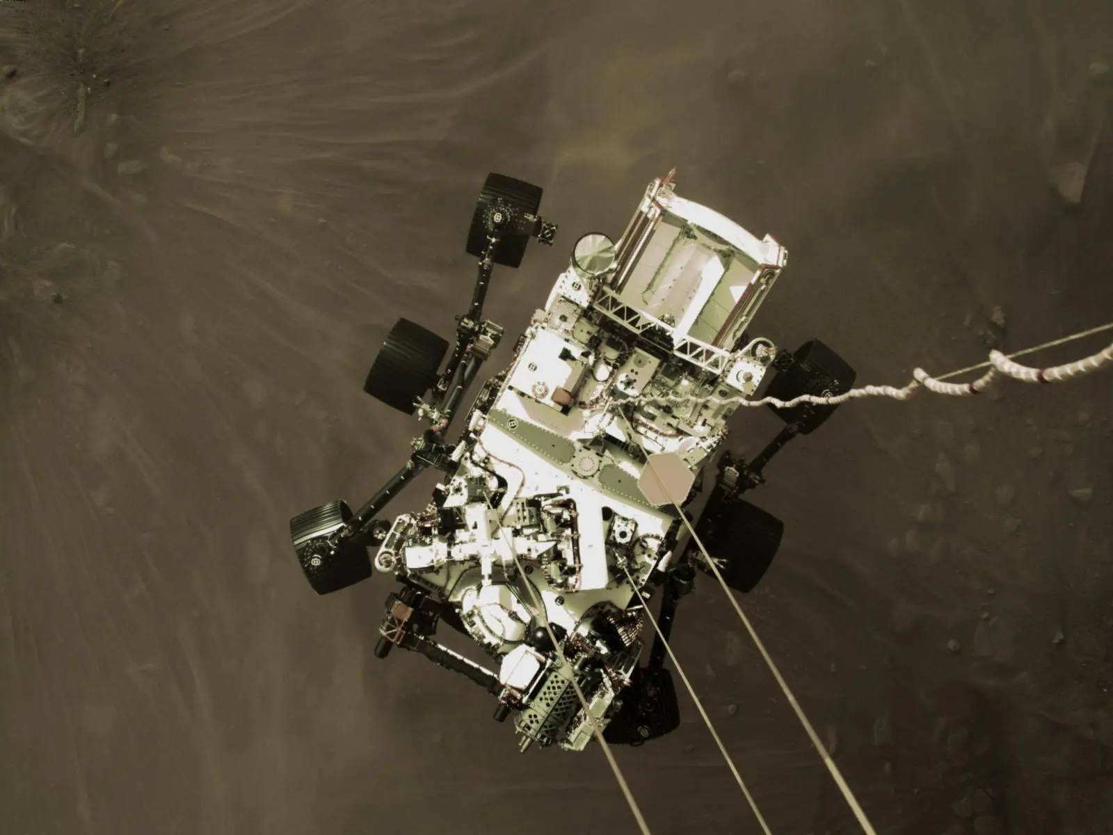 The descent stage lowers Perseverance on nylon cords seconds before touchdown in Jezero Crater, 18 February 2021