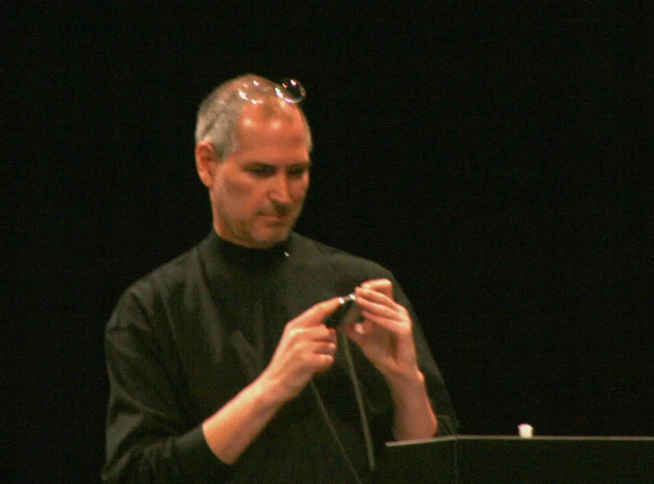 Steve Jobs holds the iPhone during his Macworld keynote, 9 January 2007