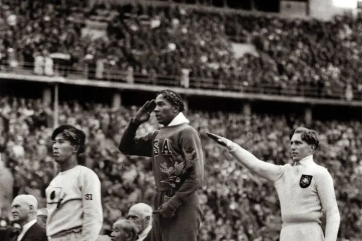 The long jump medal ceremony, Berlin, 4 August 1936: Owens salutes the flag between Naoto Tajima of Japan, third, and Luz Long of Germany, second