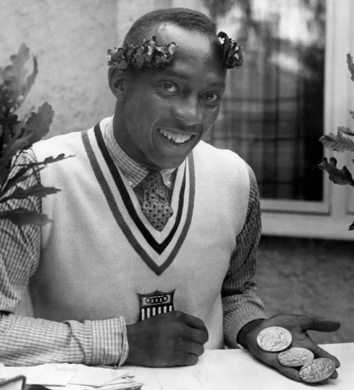 Still wearing his victor’s oak wreath, Owens holds his Olympic gold medals in Berlin, 1936