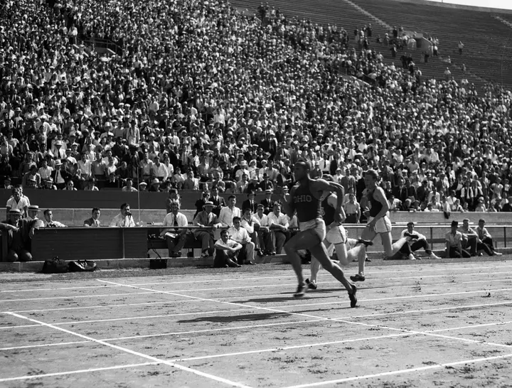 Owens of Ohio State races University of California sprinters in front of a full stadium in the 1930s