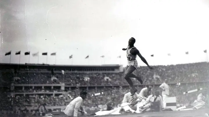 Jesse Owens in flight in the long jump at the Olympic Stadium, Berlin, August 1936