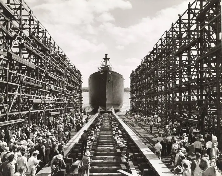 Workers crowd the ways as a newly launched Liberty ship leaves its building dock at the Kaiser yard in Vancouver, Washington.