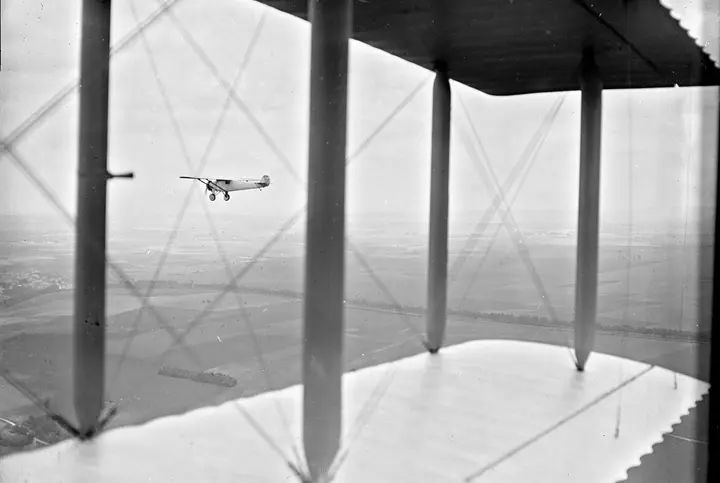 The Spirit of St. Louis flies over the French countryside, photographed from the wing of a French biplane, 1927.