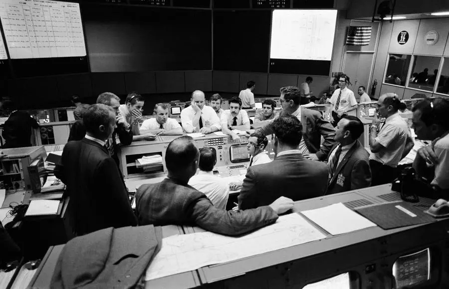 Flight controllers confer at the flight director’s console during the last day of the return, 16 April 1970 (S70-35368)