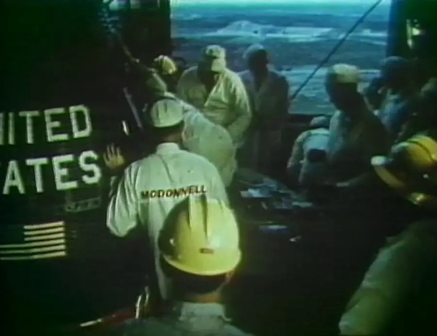 McDonnell technicians at the hatch of Friendship 7 atop the gantry, 20 February 1962 (video still)