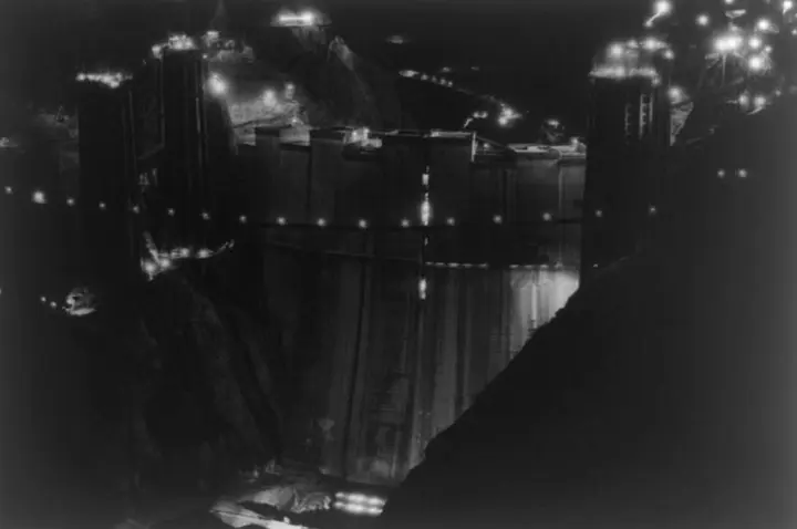 The upstream face of Boulder Dam lit for the night shift, photographed by Ben Glaha, c. 1934