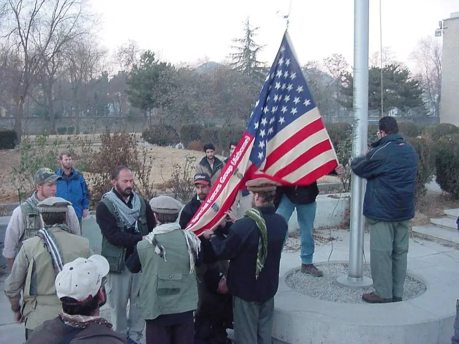 Task Force Dagger soldiers and Afghan allies raise the American flag in Afghanistan, late 2001