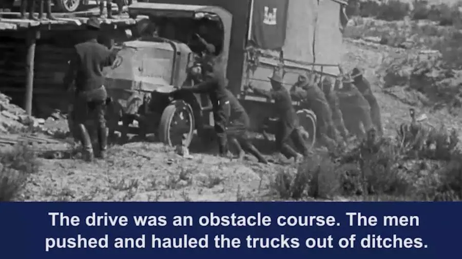 Soldiers push a stuck truck in film of the 1919 Army transcontinental convoy.