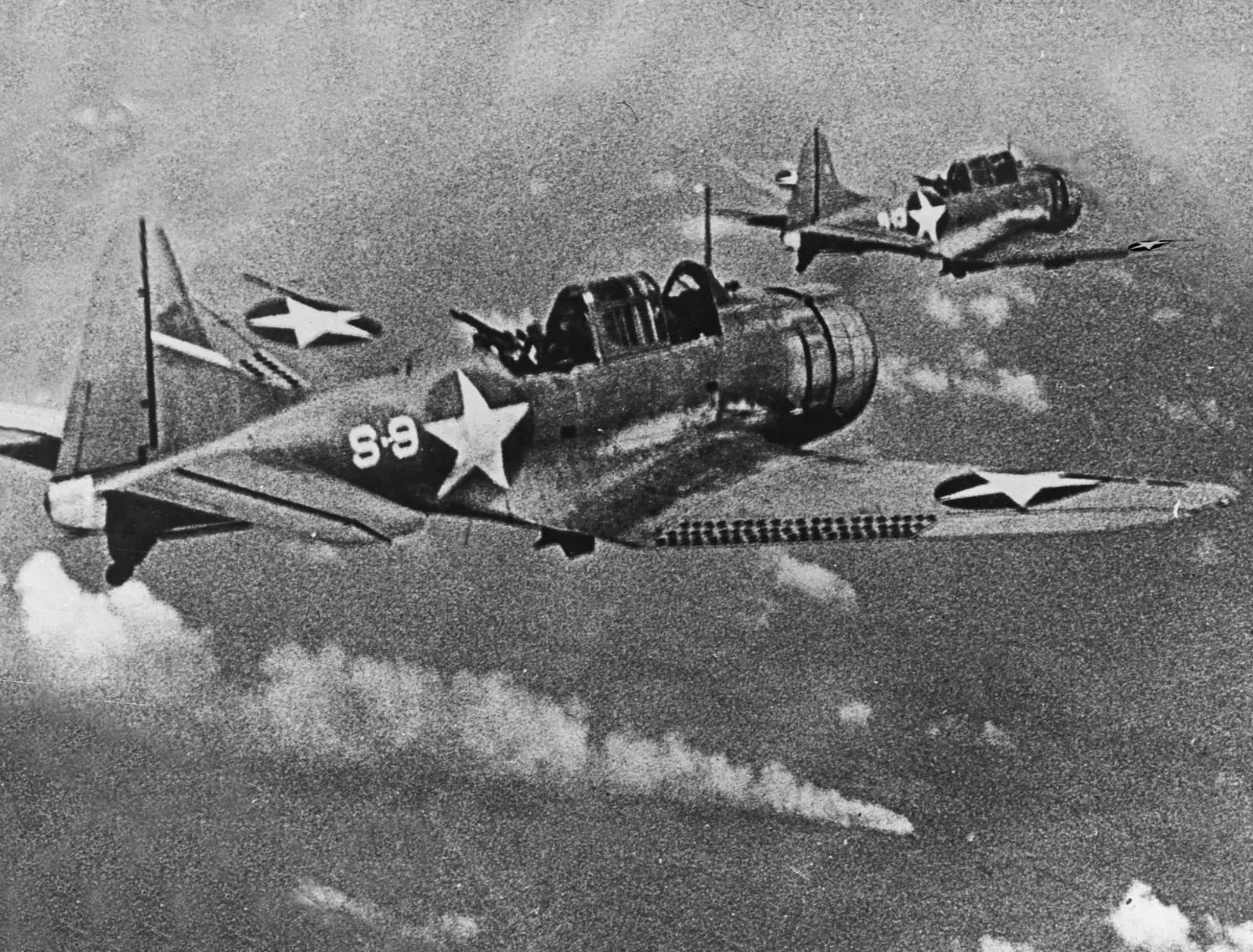 Dauntless dive bombers of Scouting Squadron 8 from USS Hornet close on the burning Japanese heavy cruiser Mikuma, 6 June 1942 (80-G-17054).