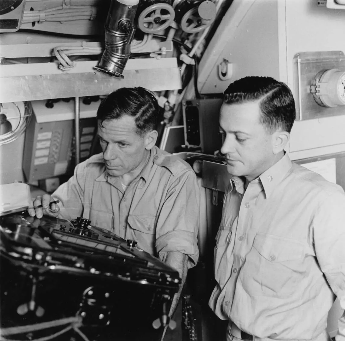 Dr. Waldo Lyon (left) and Cmdr. William Anderson read the ice overhead on the recorder in the attack center, August 1958.