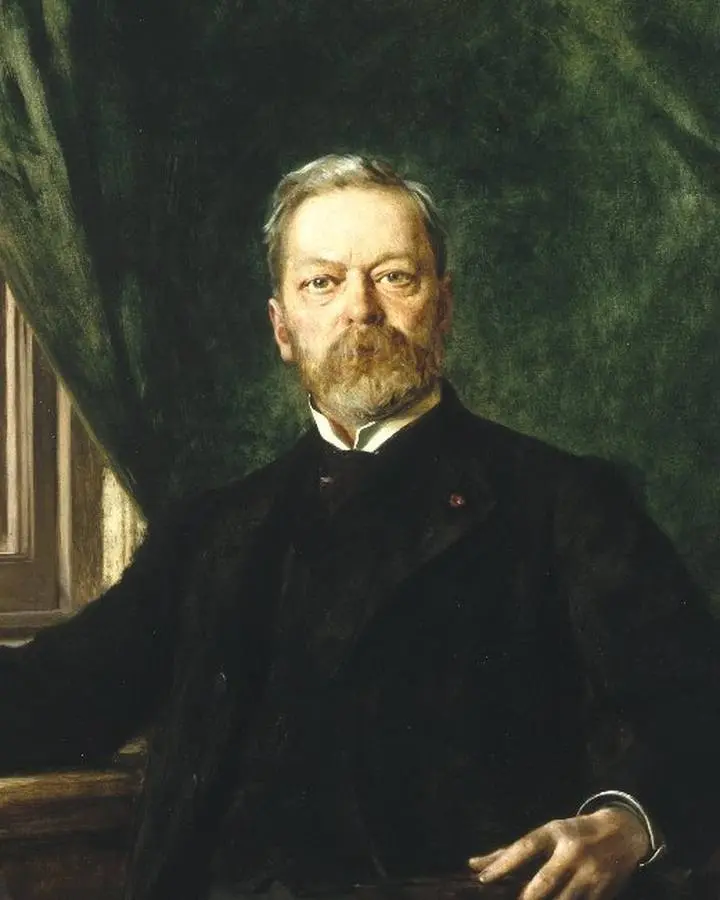 Washington A. Roebling, with his bridge in the window behind him, about 1899.