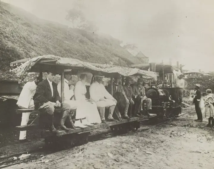 President Roosevelt, in white, and his party tour the canal works on a flag-draped rail car, November 1906