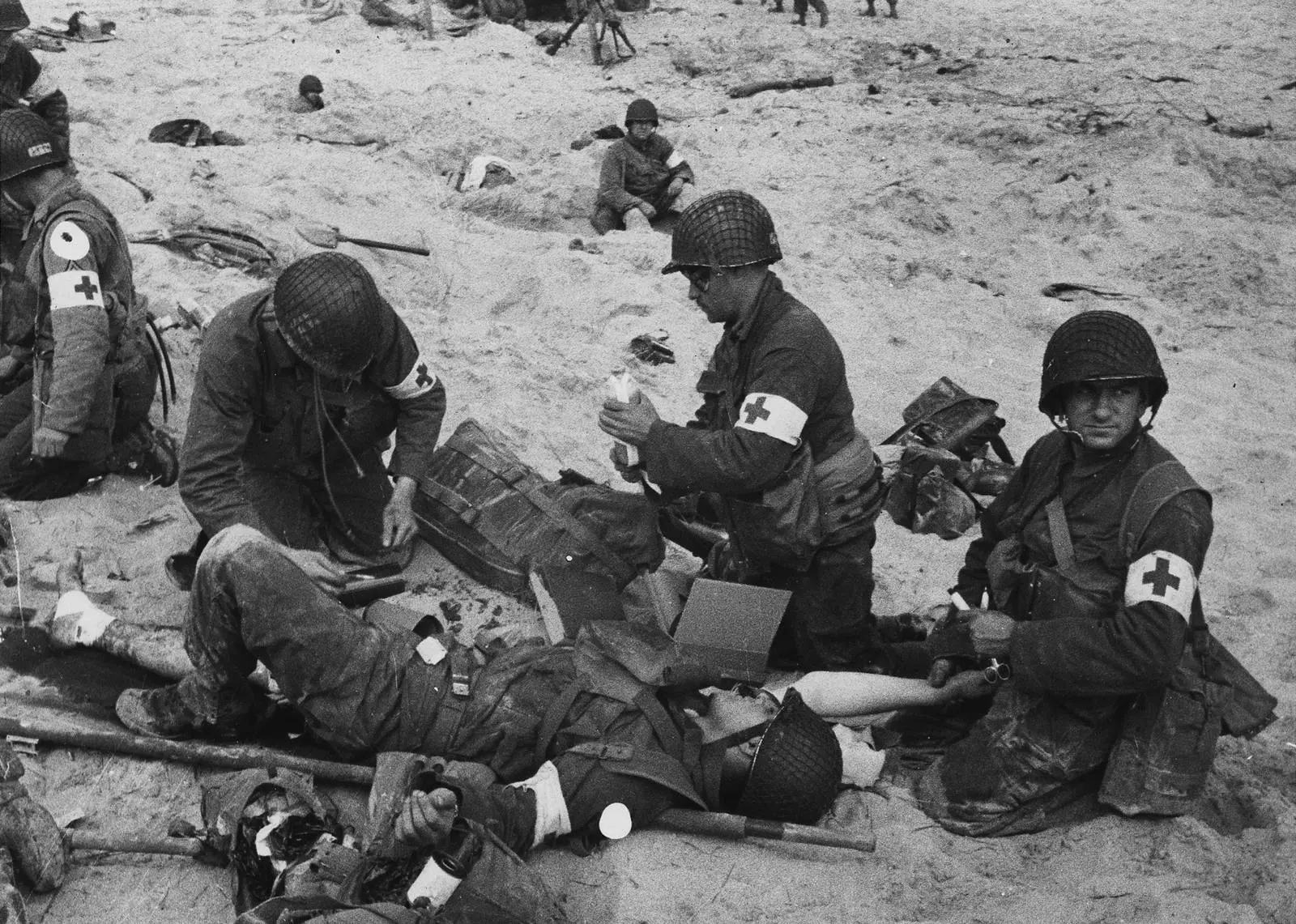 Army medics treat American wounded on a Normandy beach in the first days of the invasion, June 1944.