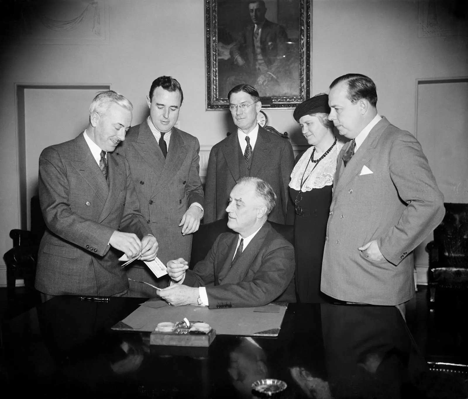 President Roosevelt buys a certificate enrolling him as a founder of the National Foundation for Infantile Paralysis, 17 January 1938.