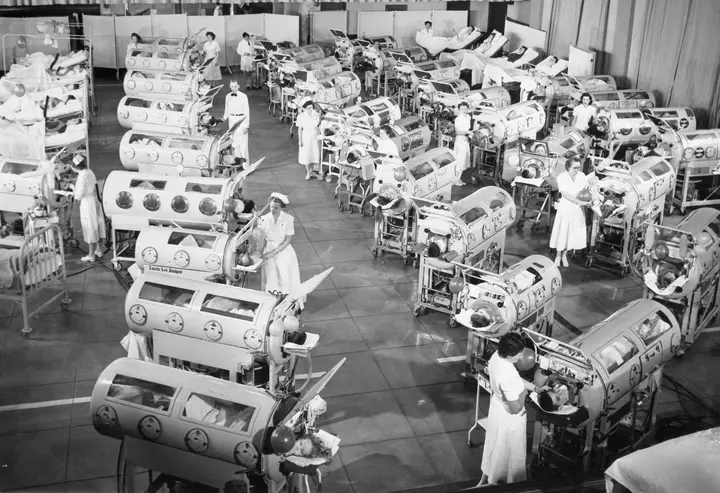 Rows of iron lungs breathe for polio patients in a hospital ward, about 1953.