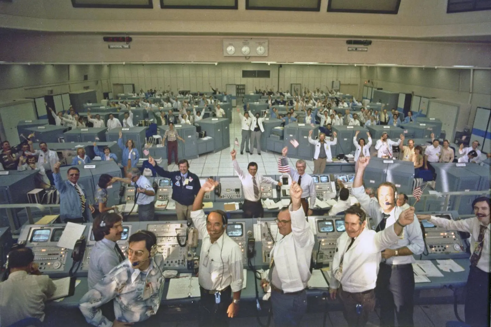 The STS-1 launch team at Kennedy Space Center cheers as Columbia lifts off, 12 April 1981 (KSC-81PC-0364)