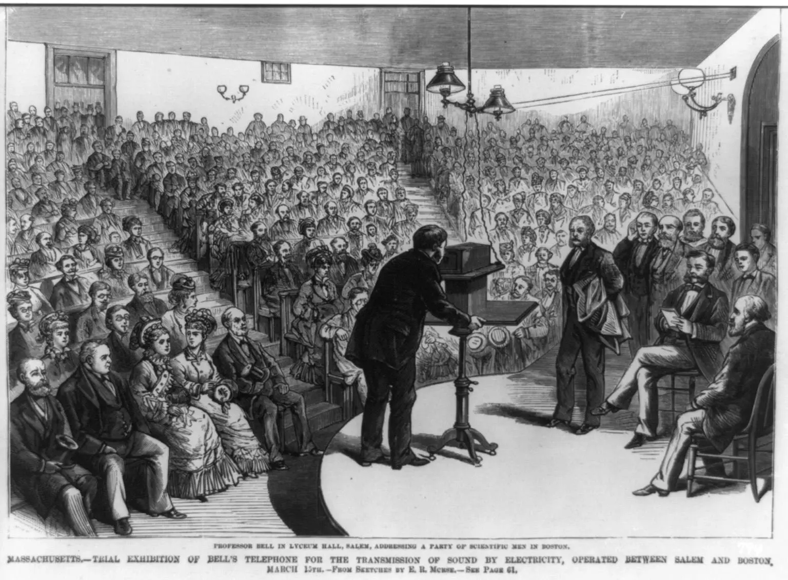 Bell demonstrates the telephone to a packed Lyceum Hall in Salem, Massachusetts, in 1877, with voices carried by wire from Boston. Wood engraving from sketches by E. R. Morse.