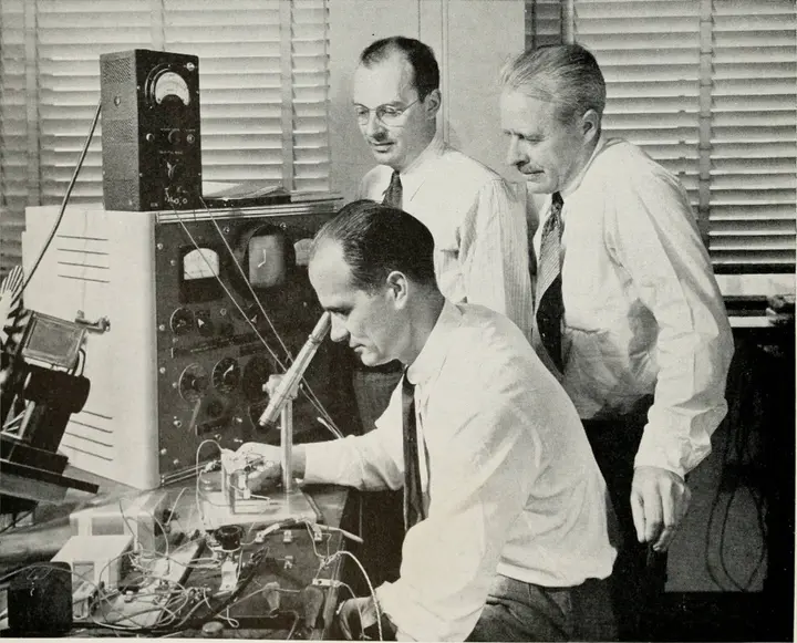 Brattain at the bench with Bardeen and Shockley behind him, from Bell Telephone Magazine, 1948