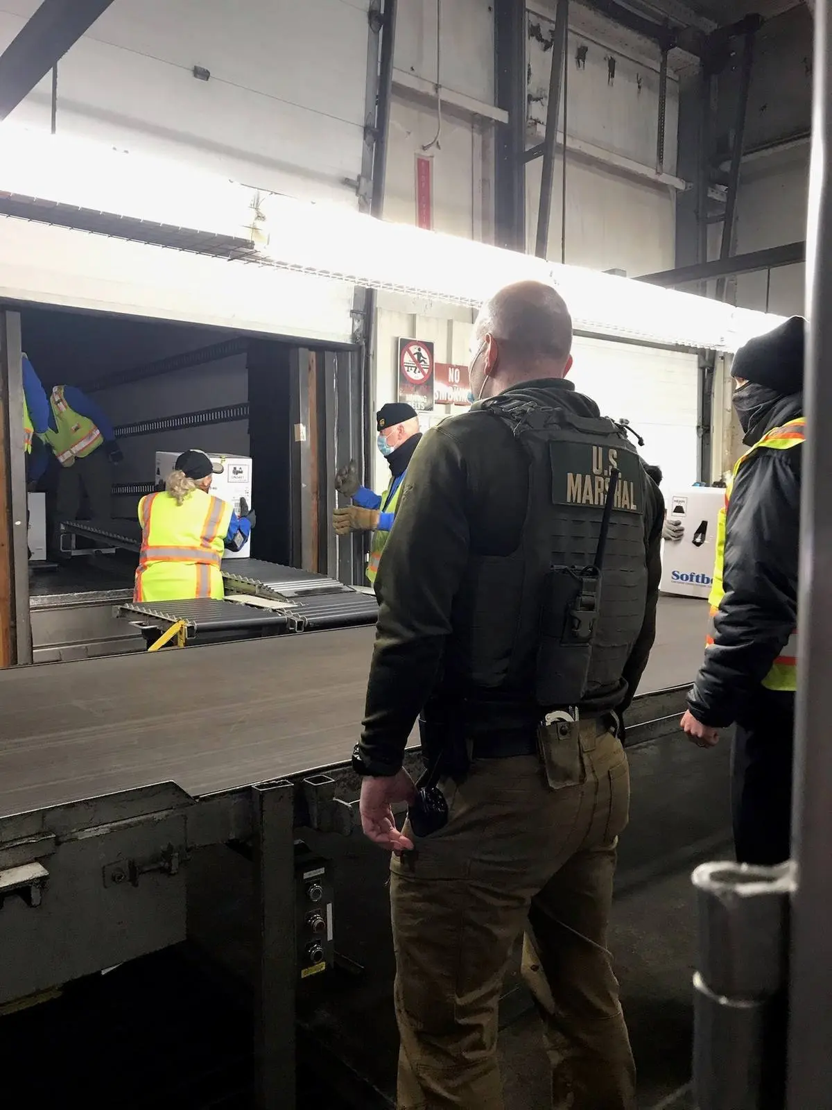 A Deputy U.S. Marshal watches over a vaccine shipment at a loading dock during the first deliveries, 14 December 2020.